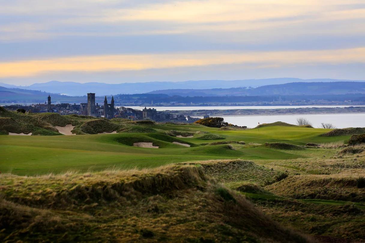 A fairway with rolling dunes leading to a smooth green with coastal views