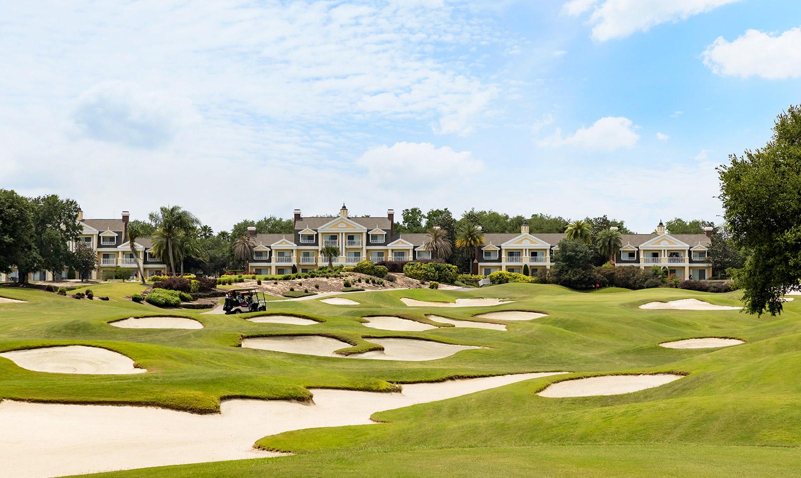 Panoramic view of a fairway littered with sand bunkers leading to a smooth green