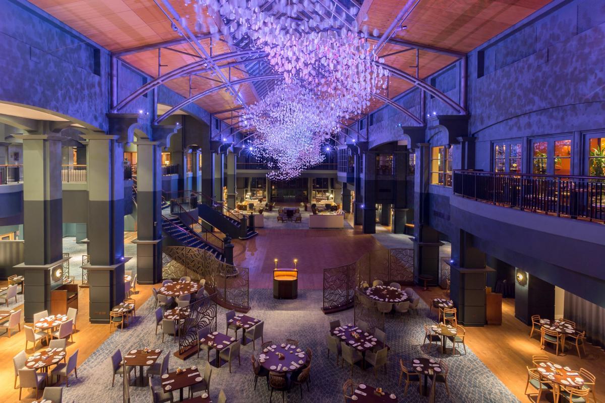 Overhead view of dining room at the resort with a grand chandler with a vibrant purple light and high ceilings
