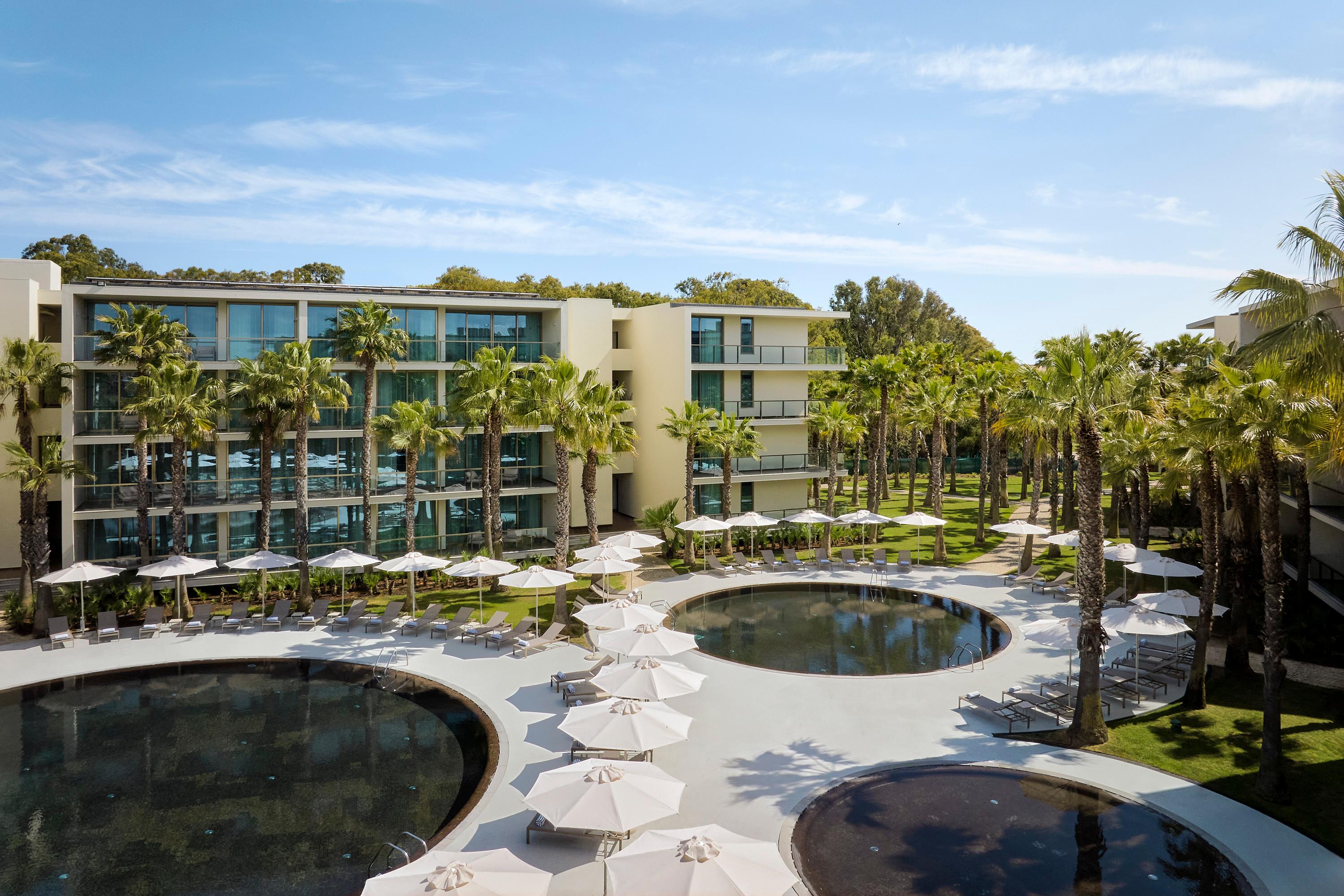 Outdoor swimming pools and pam trees at the Marriott Residence Salgados Resort