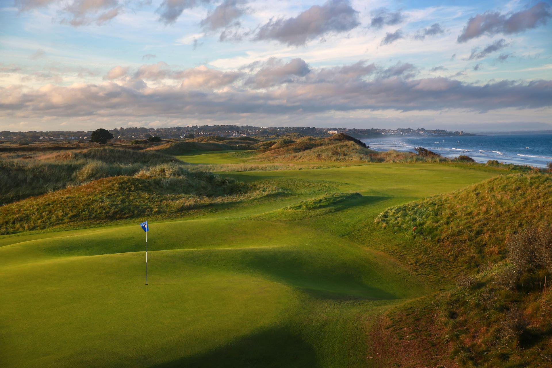 A winding fairway leading to a smooth green with coastal views