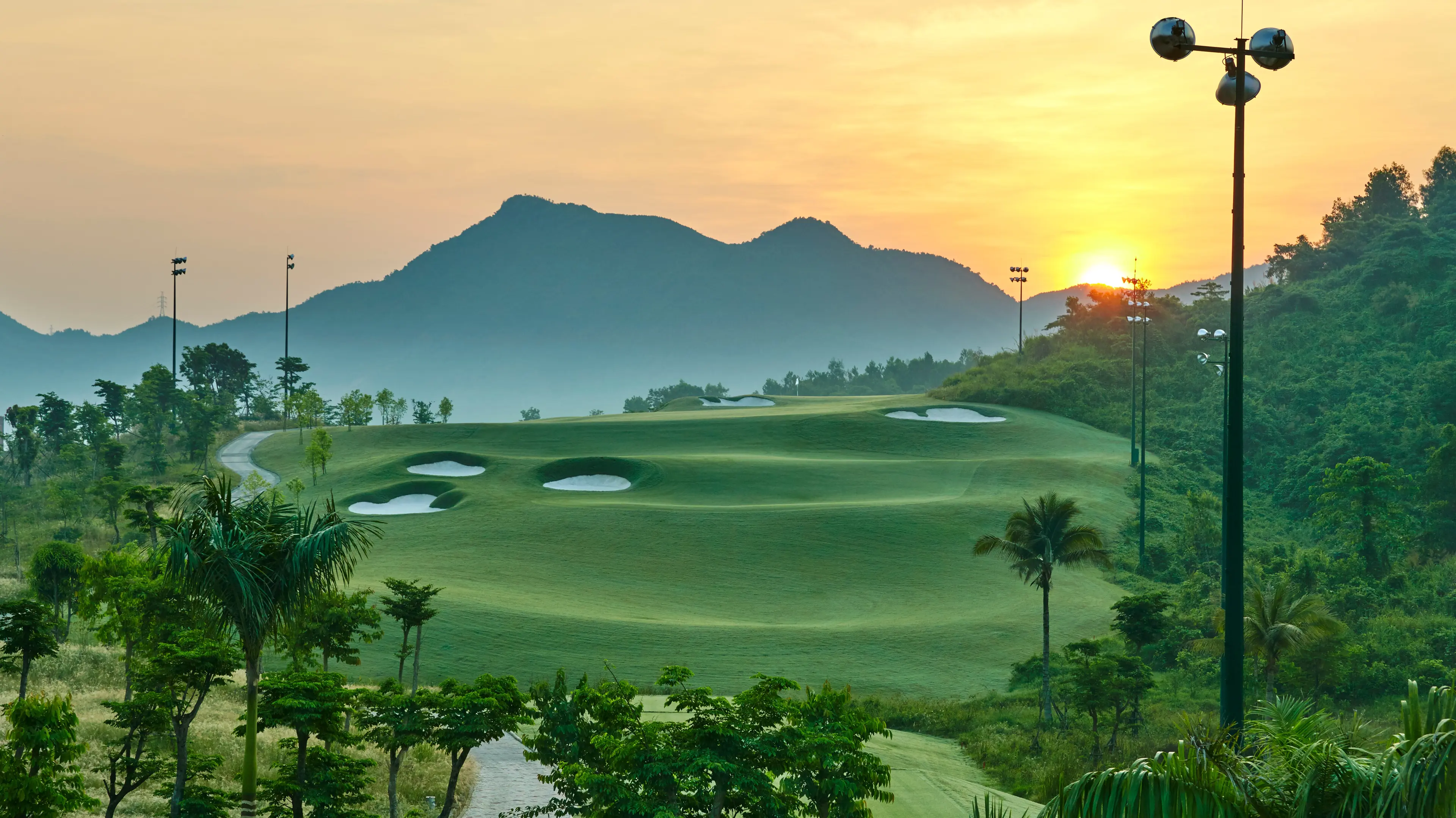 Panoramic view of a well maintained fairway at sunset with distant mountain views