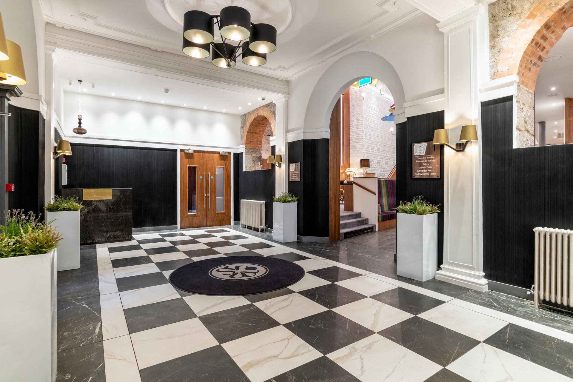 Front entrance to Sandman Signature Aberdeen Hotel with a black and white floor design