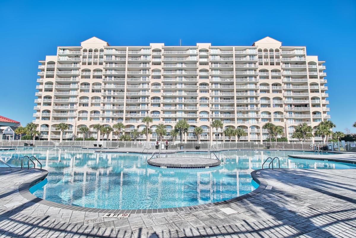 Exterior view of the resort building towering over the outdoor swimming pool