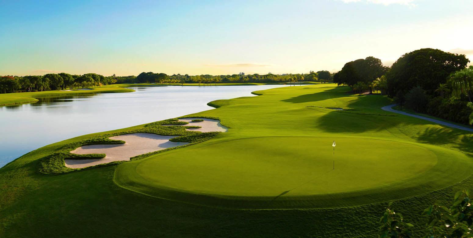 A peaceful green located beside a wide, calm lake with strategically placed bunkers.