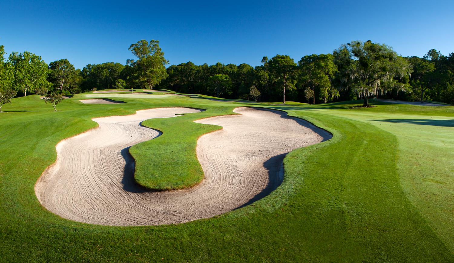 Uniquely shaped large sand bunker around the green
