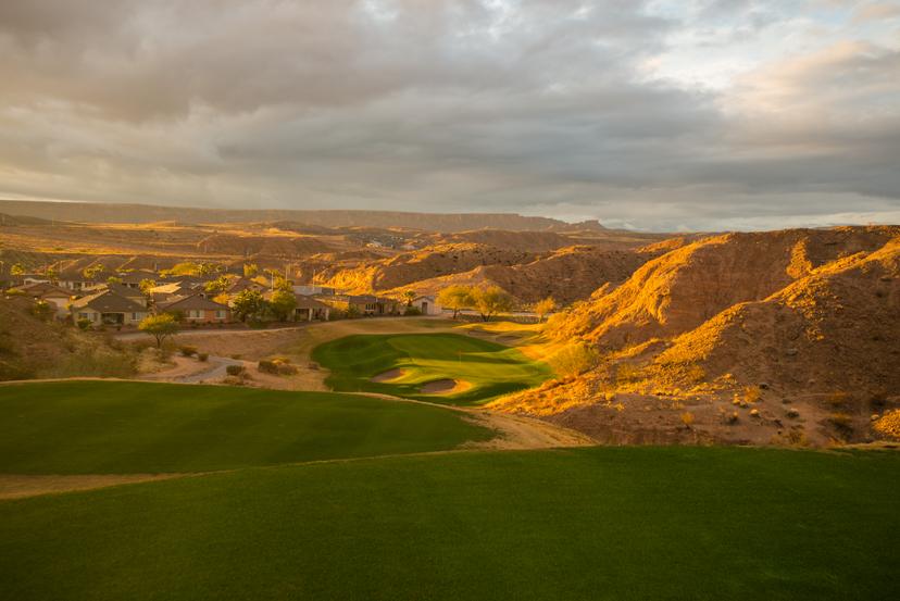 A winding fairway surrounded by stone desert mountains