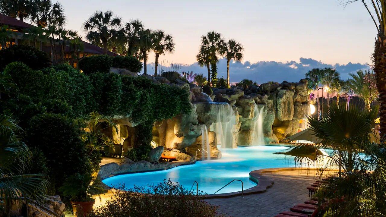 Outdoor swimming pool at the hotel with water fountain feature that leads through to a cave