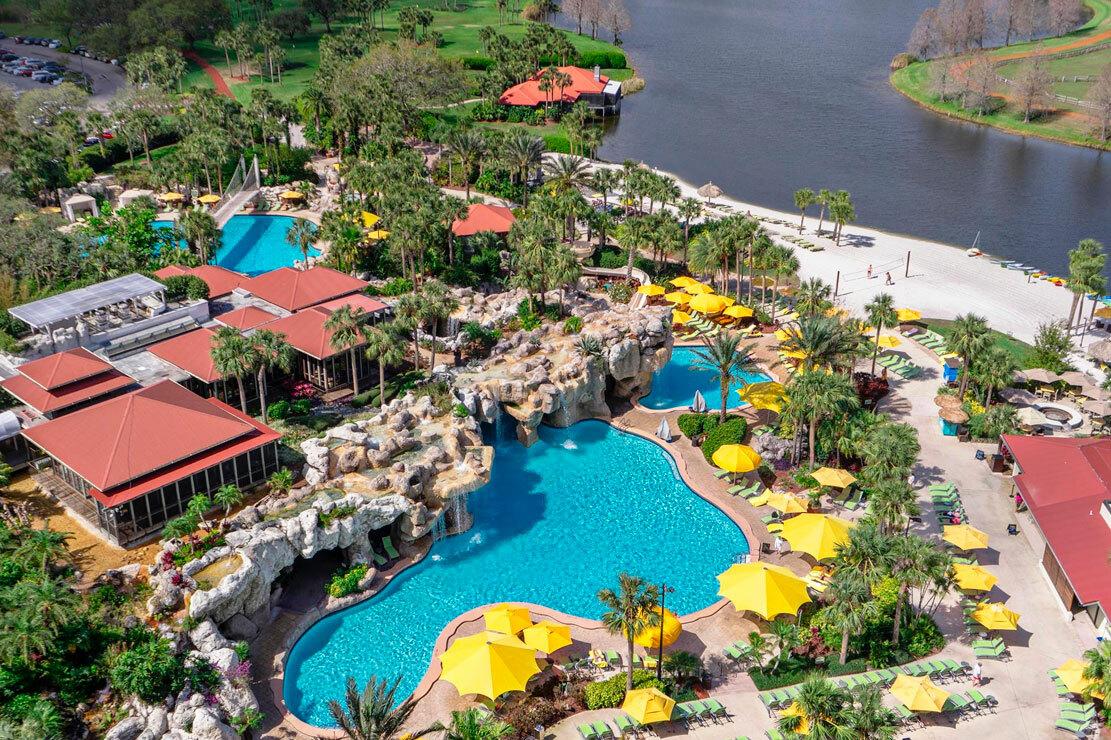 Aerial view of two outdoor swimming pools with multiple sunbed section and a rocky design