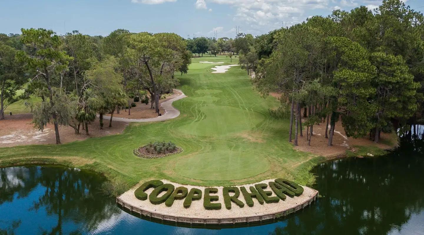 Aerial view of Copperhead spelt out in bushes on its course with smooth green and sand bunker in the background
