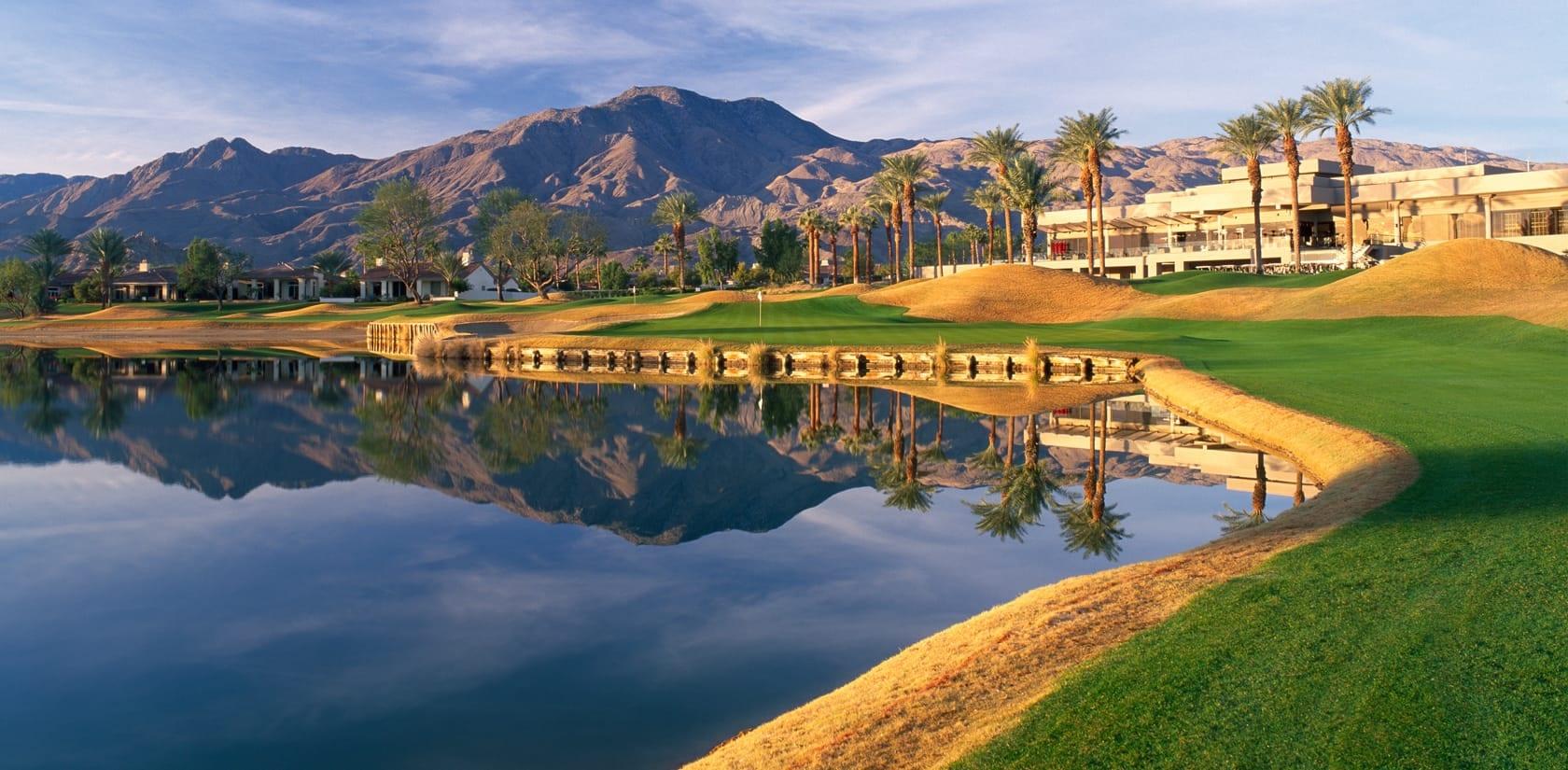 Panoramic view of the La Quinta Resort looking through palm trees over the course with mountains in the back