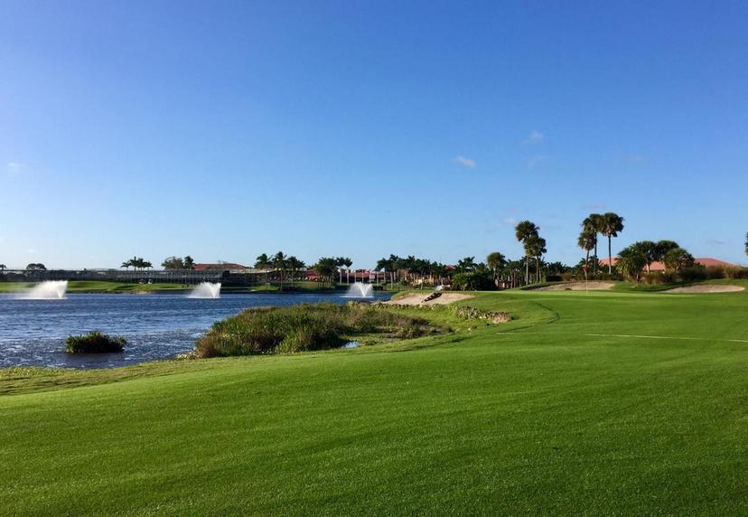 Well maintained fairway leading to a green neighbouring a water hazard equipped with water fountains