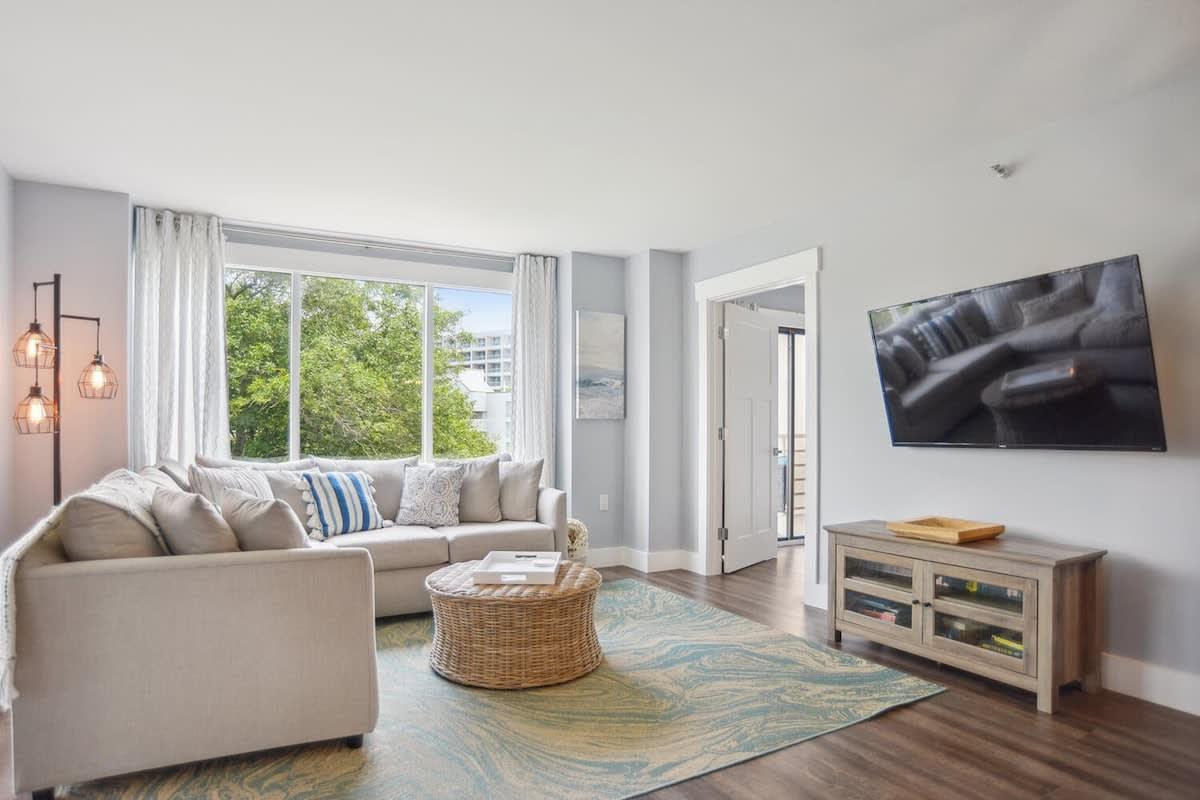 Living room as part of a suite with a corner sofa, panoramic windows and a large flat screen TV