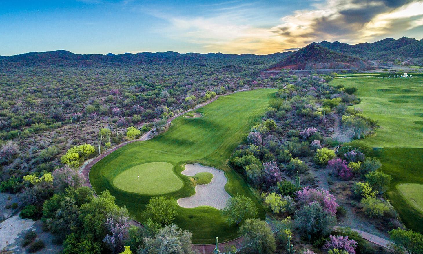 Birdseye view of a smooth green nestled with a large sand bunker at the Quintero Golf Course