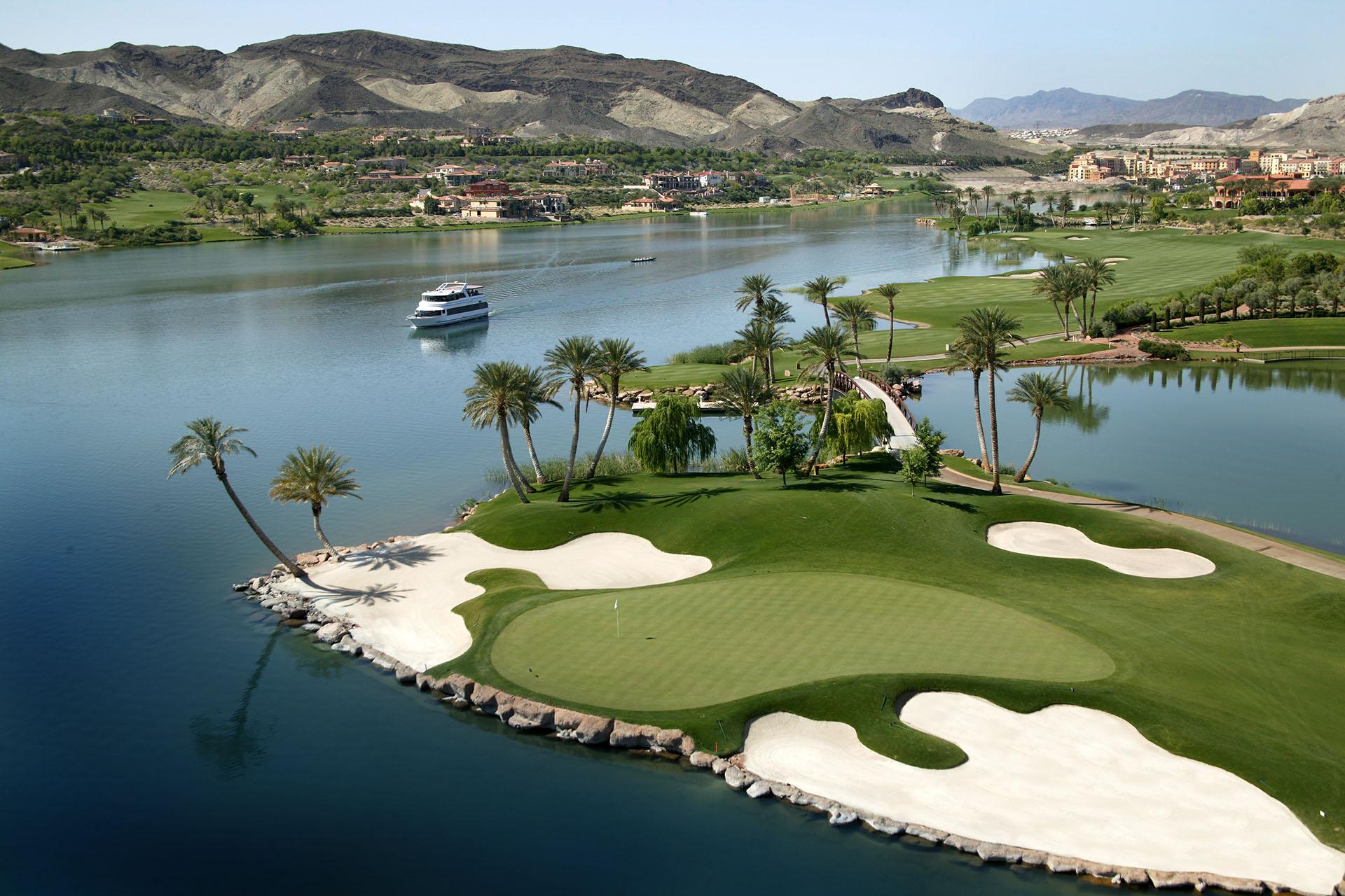 Stunning island green surrounded by palm trees and crystal-clear lake waters at the Reflection Bay golf course.