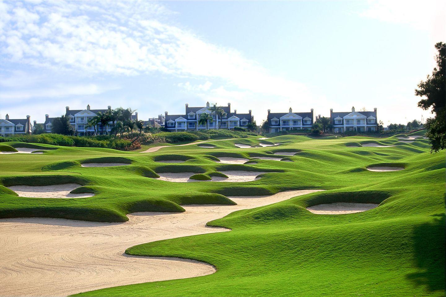The Reunion Resort's golf course littered with different shaped and sized sand bunkers with lodges in the back