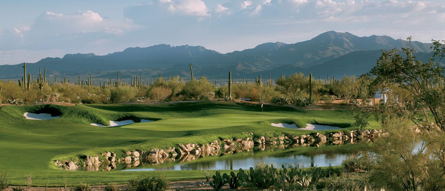 A wide fairway nestled with sand bunkers running next to the water hazard