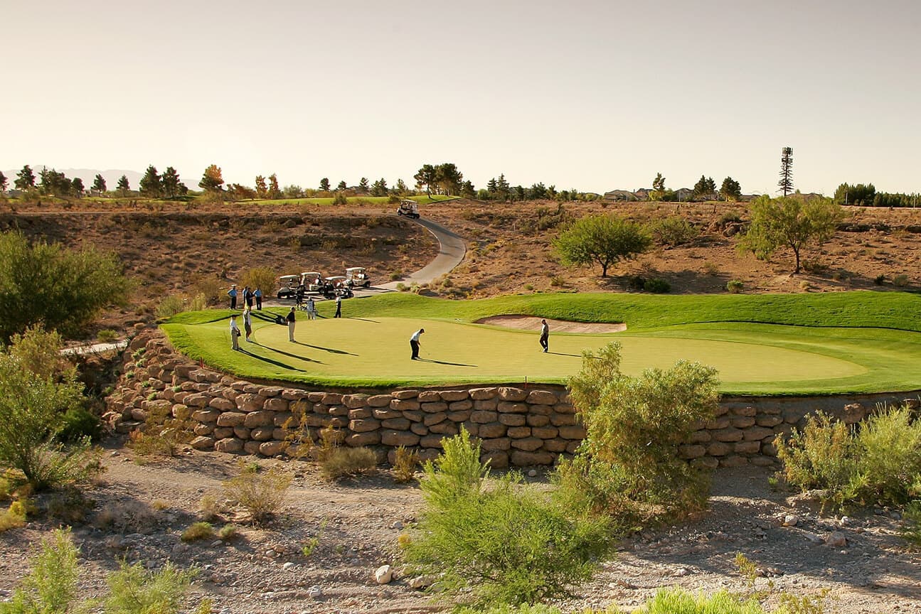 Large group of golfers putting on a smooth elevated green at the TPC Las Vegas course
