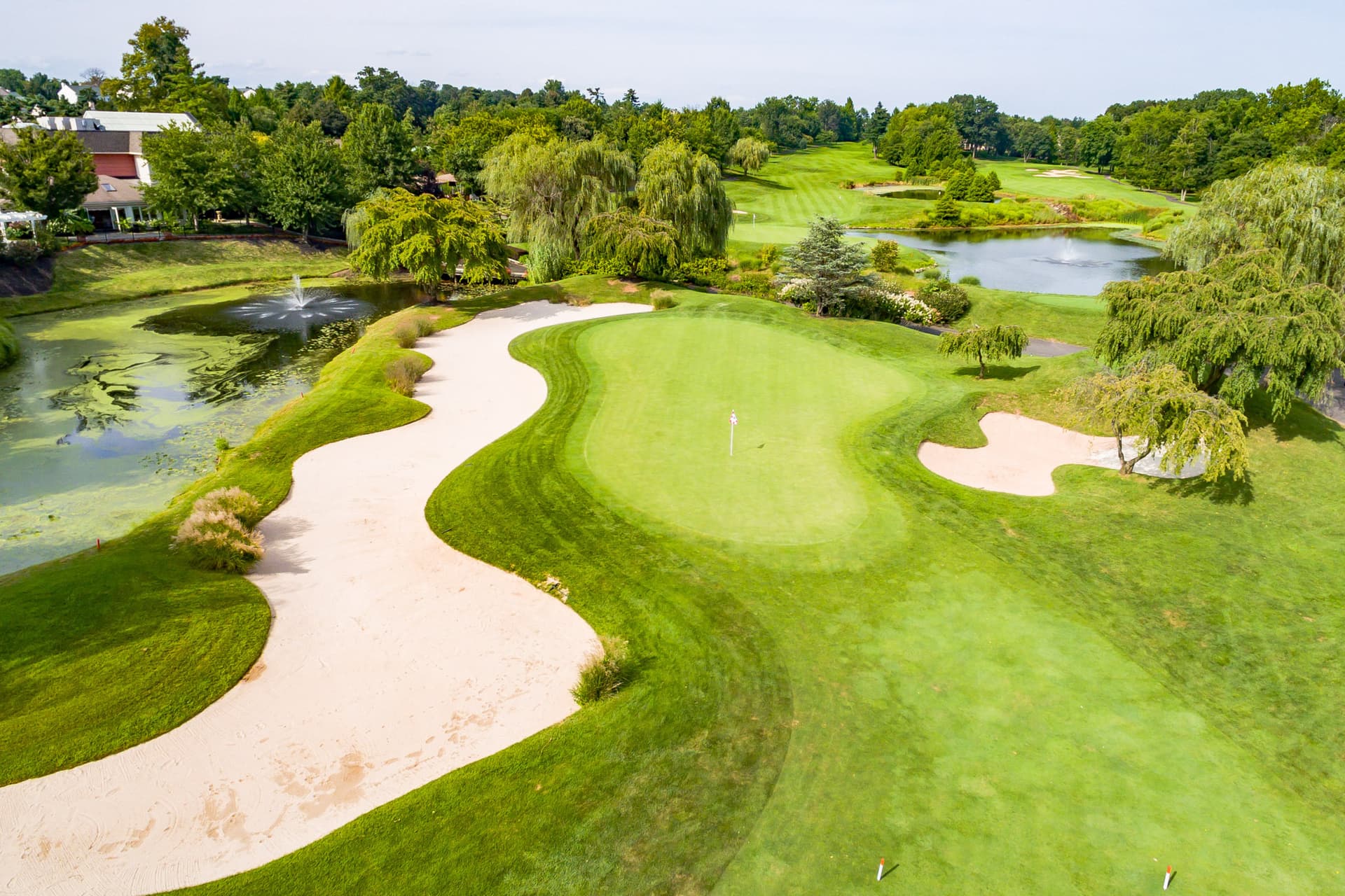 Overhead view of a manicured green sandwiched between two sand bunkers