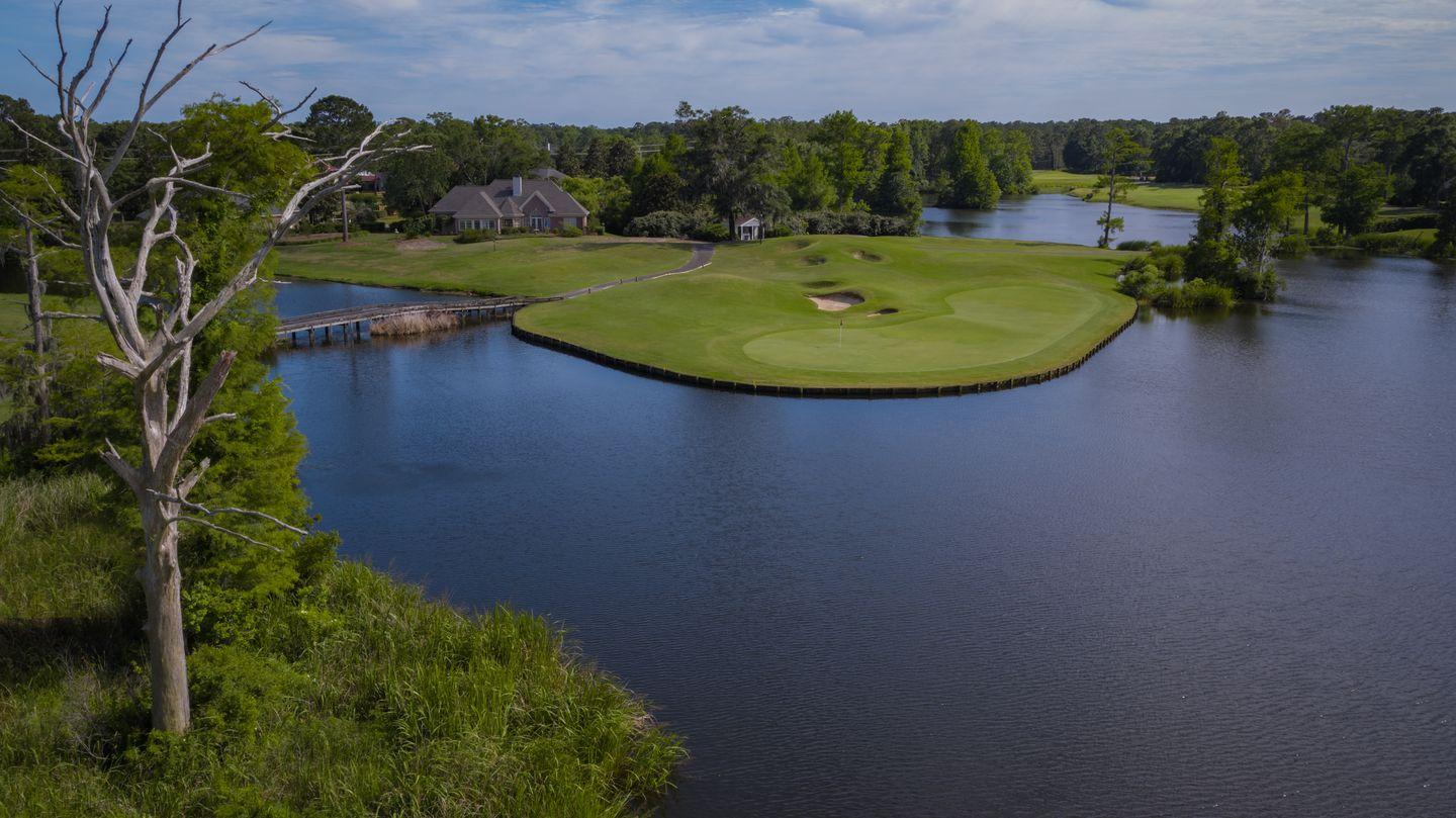 Overhead view of a smooth green next to a large water hazard