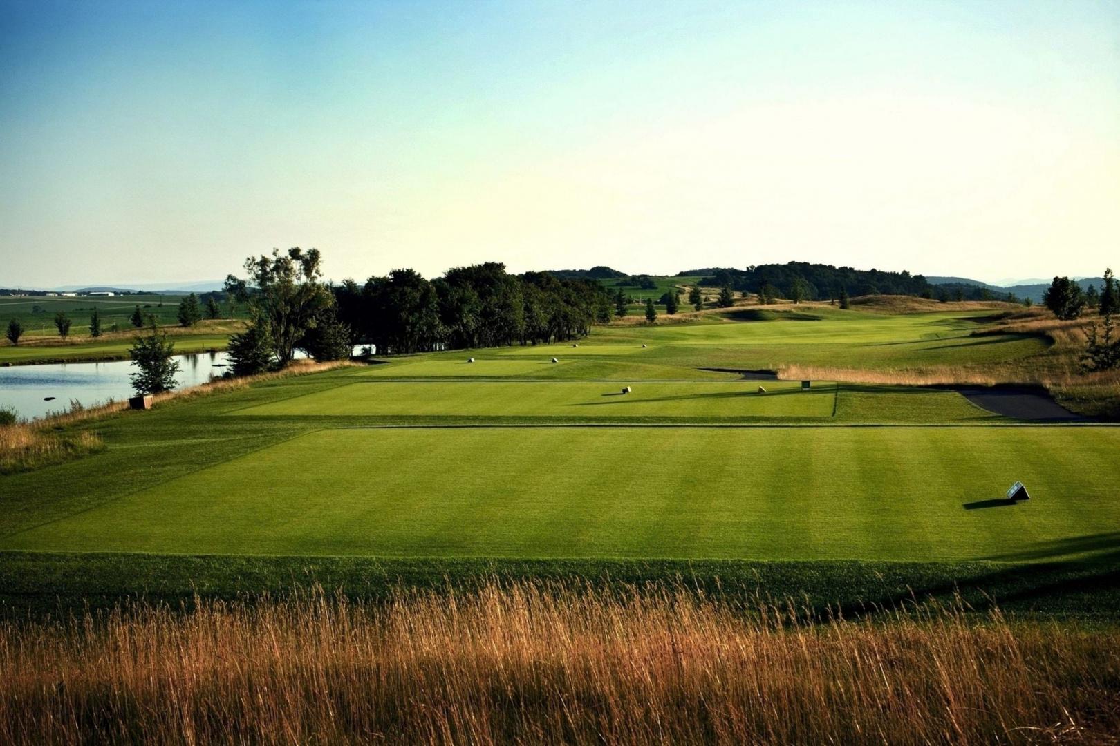 Multiple sized tee boxes leading to a winding fairway under clear skies