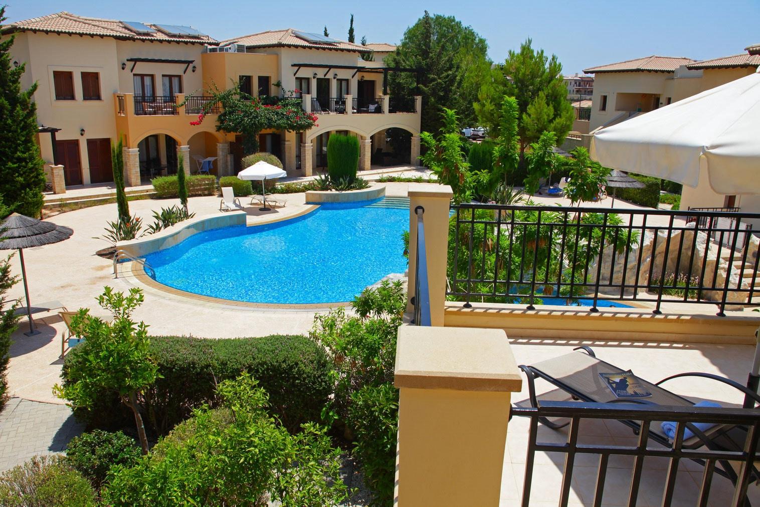 Balcony point of view of a shared outdoor swimming pool nestled with vibrant nature