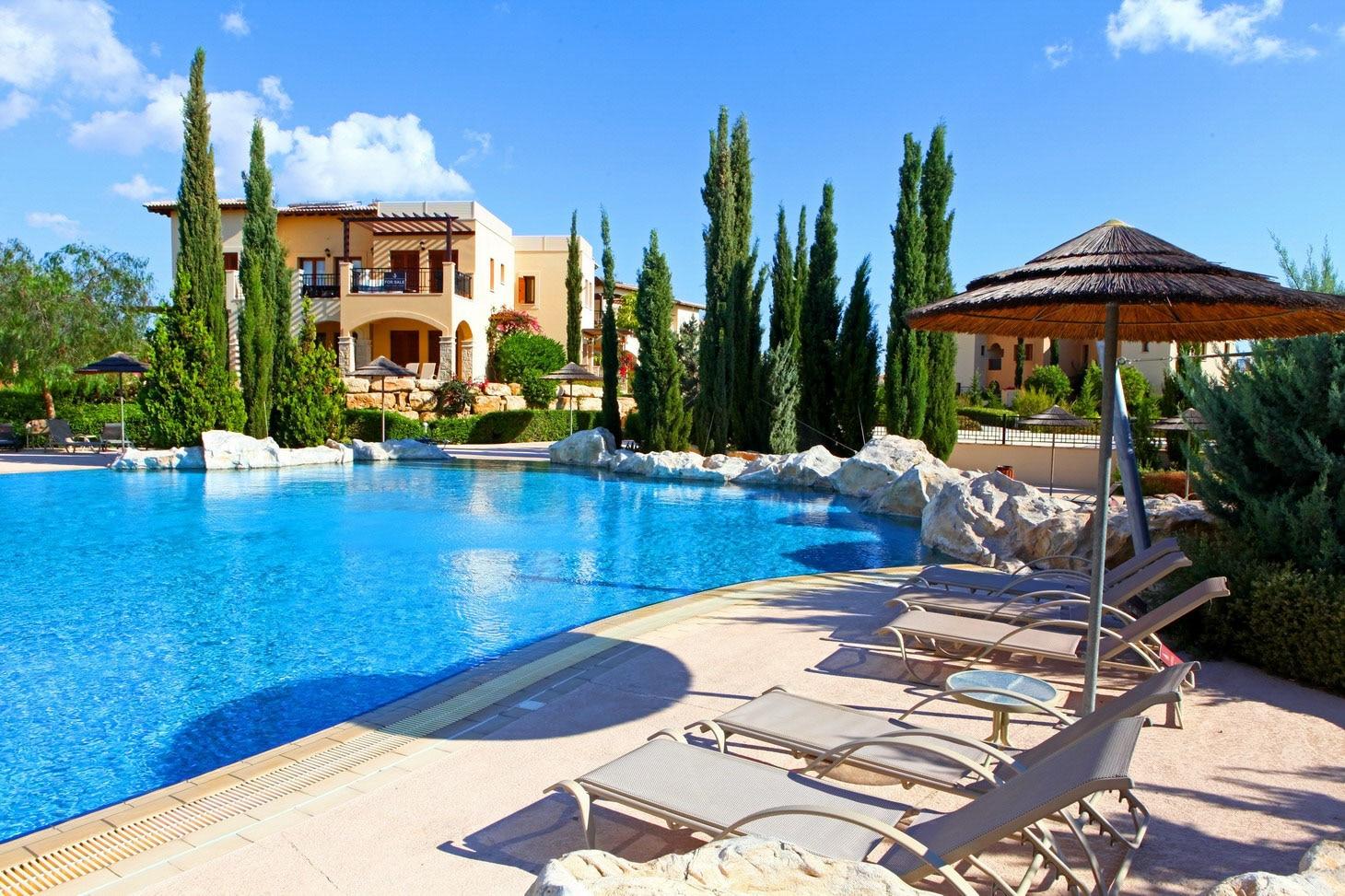 A pool designed with rock features and nestled with sun beds