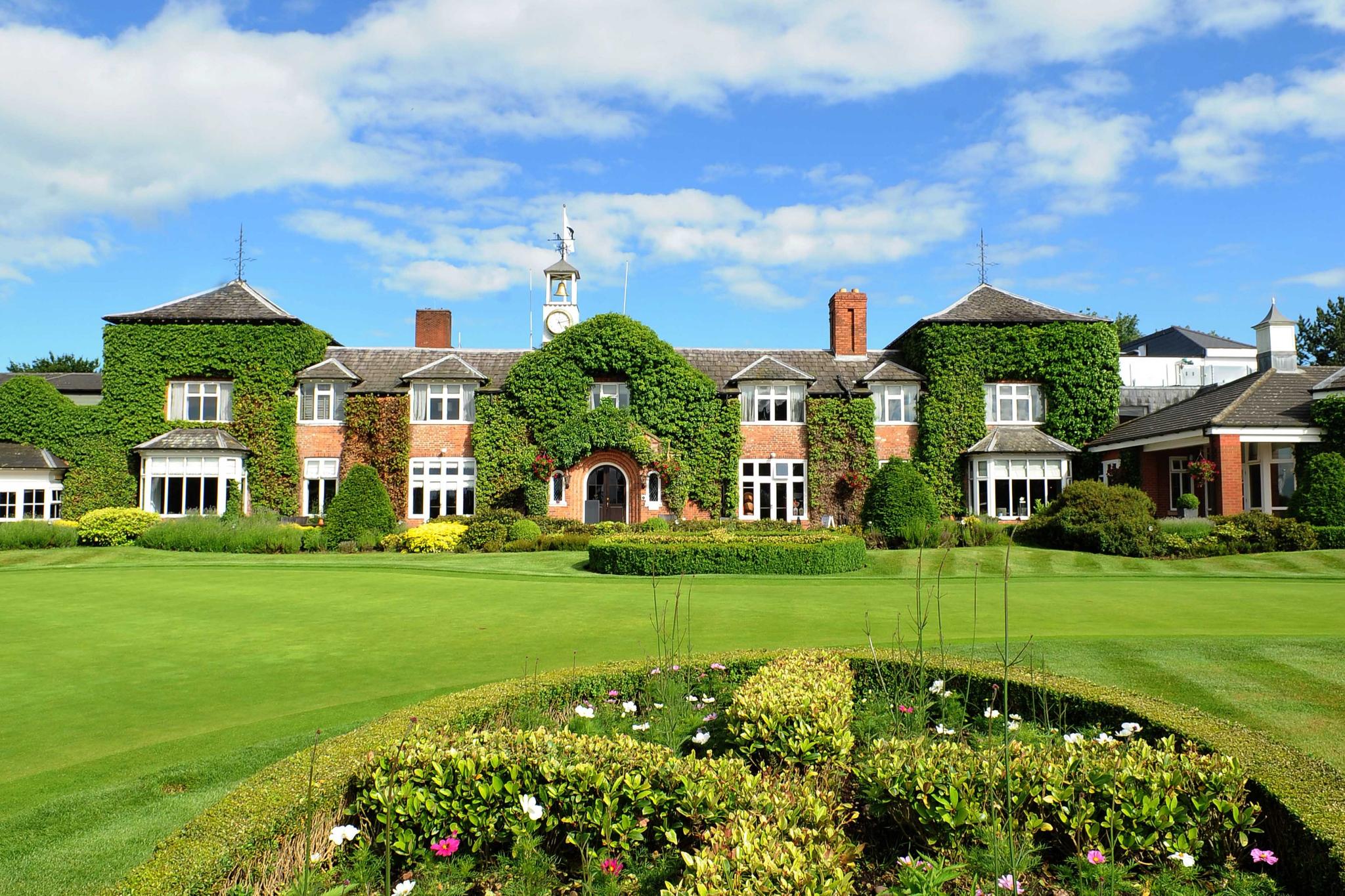 Exterior view of The Belfry hotel building covered in controlled nature looking out onto the course