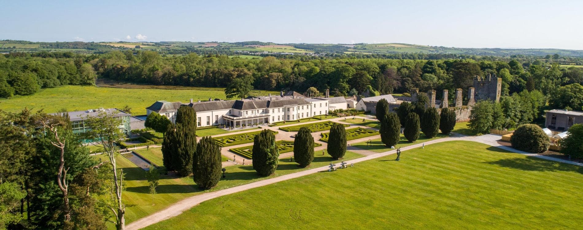 Aerial view of the resort grounds featuring landscaped gardens, historic ruins, and surrounding countryside.