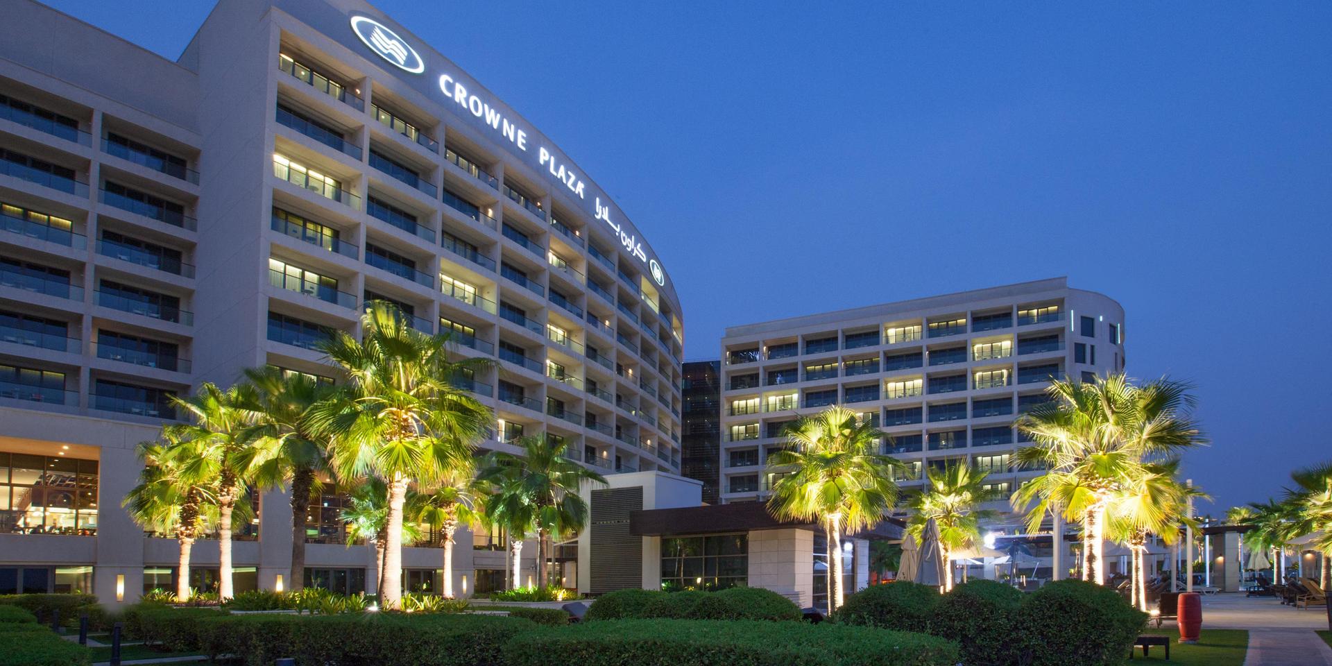 Exterior view of the Crowne Plaza Yas Island building with their name illuminated at the top of the building