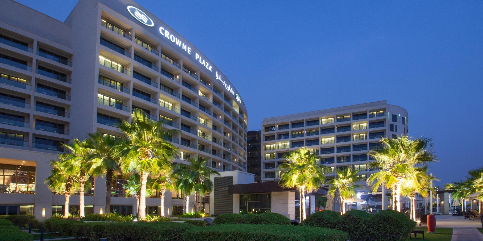 Exterior view of the Crowne Plaza Yas Island building with their name illuminated at the top of the building