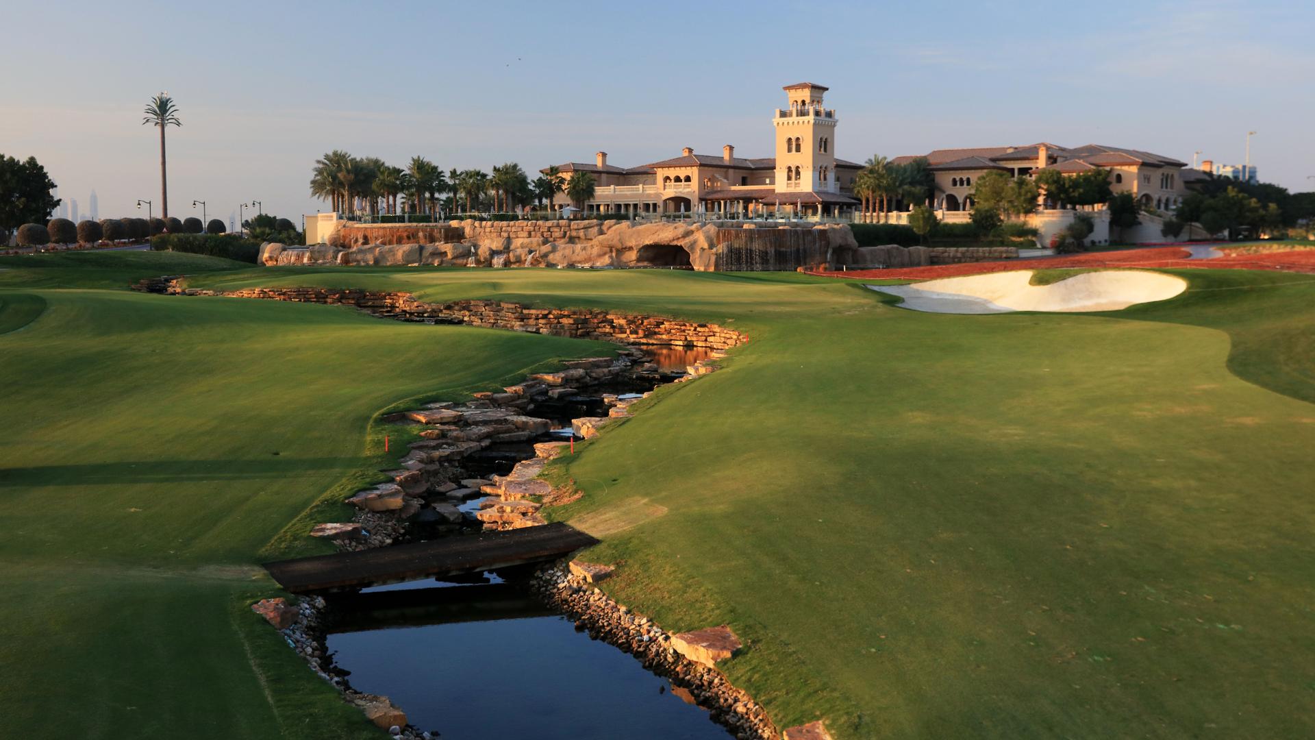 Dubai Earth Golf Course with small lake and bridge at sunset