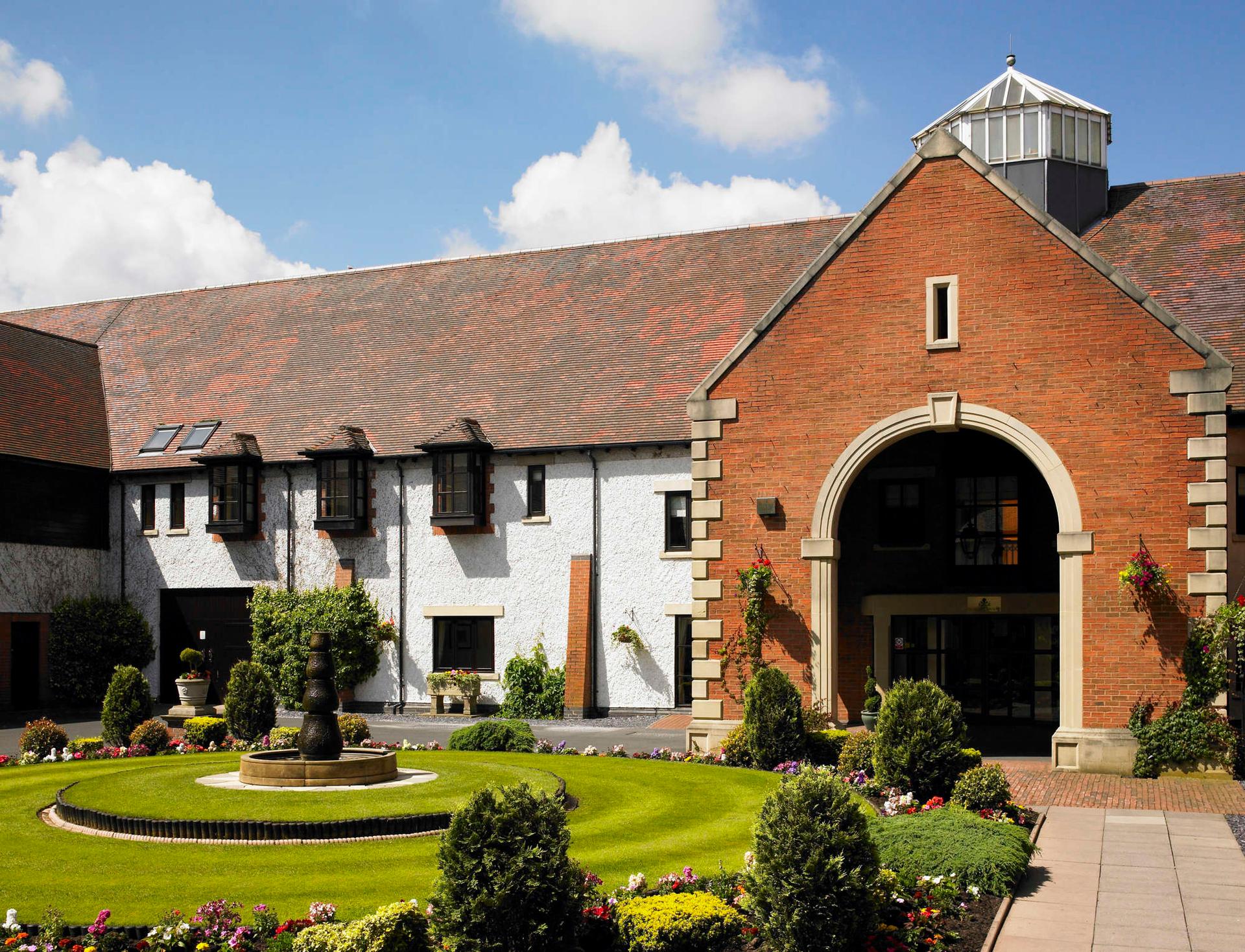 Grand entrance at the hotel with a outstanding archway and vibrant garden