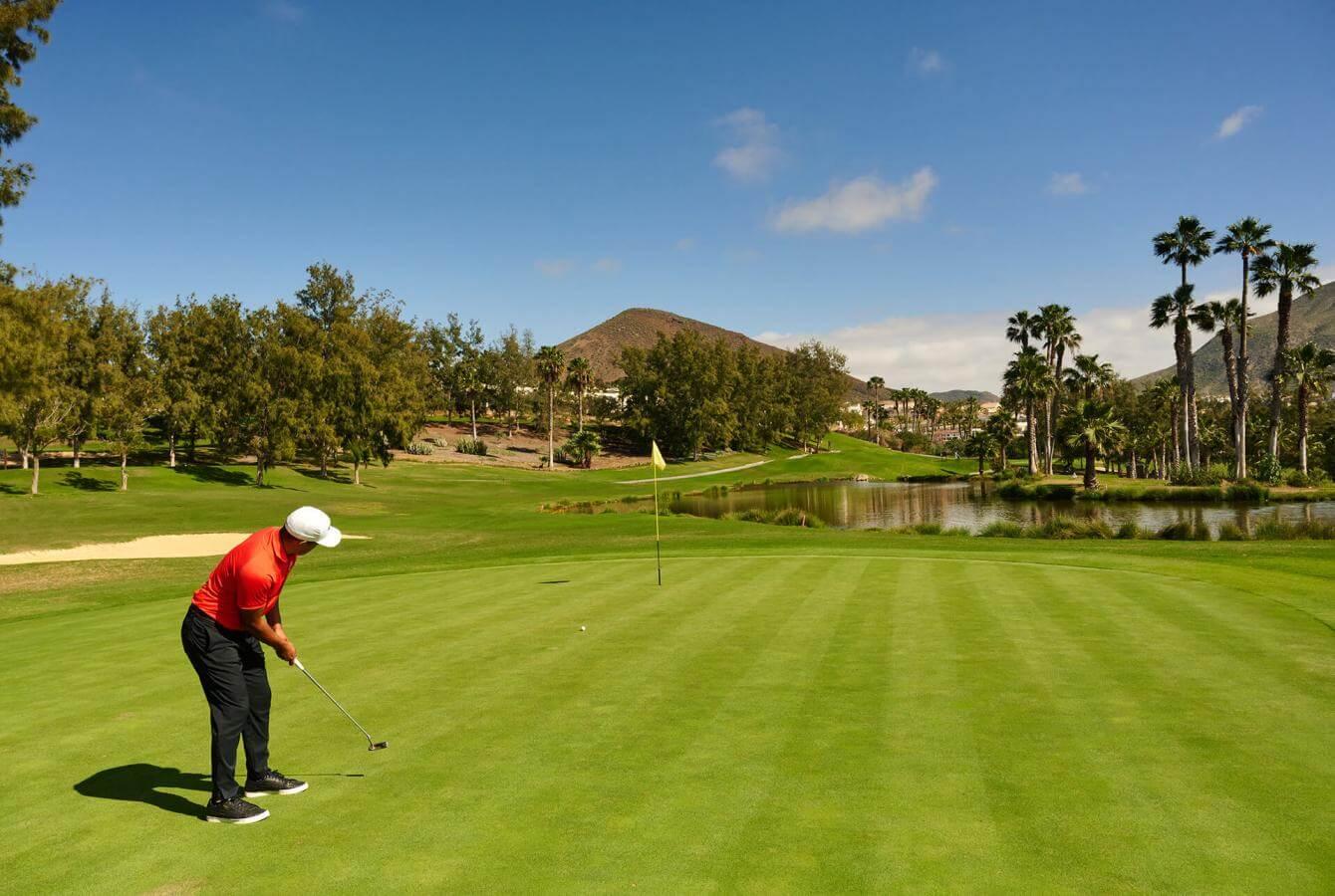 Man in red polo putting