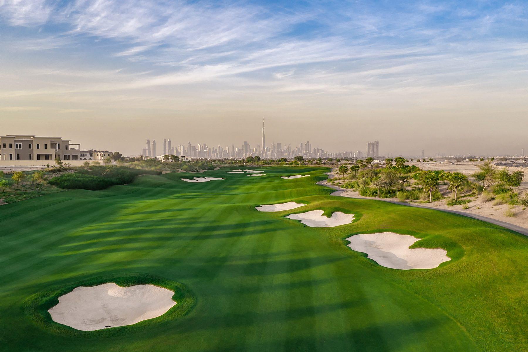 Green golf course with sand bunkers and skyline view