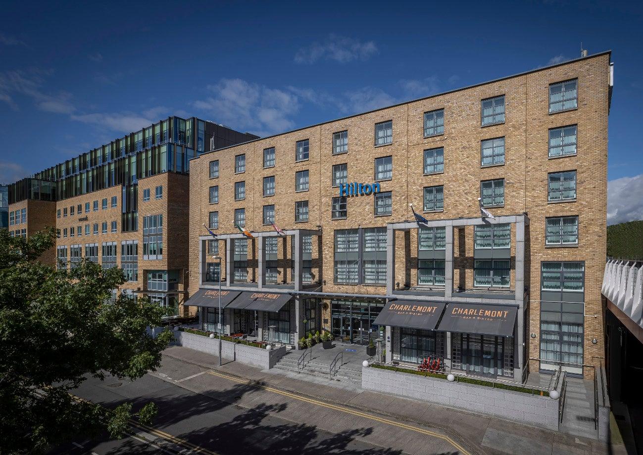 Modern exterior of Hilton Dublin with a clear blue sky backdrop.