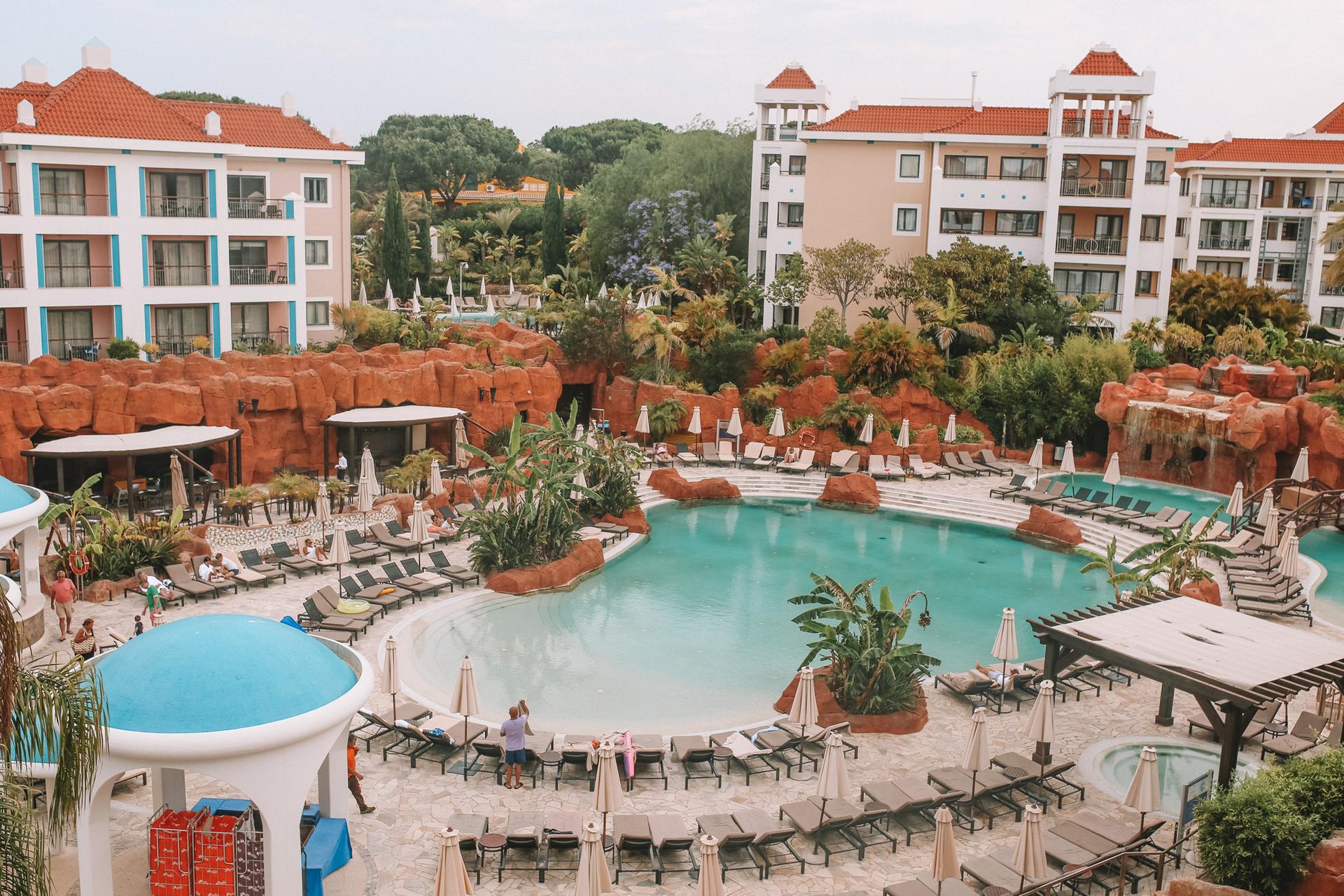 Outdoor swimming pool area with the lounge area and hotel visible