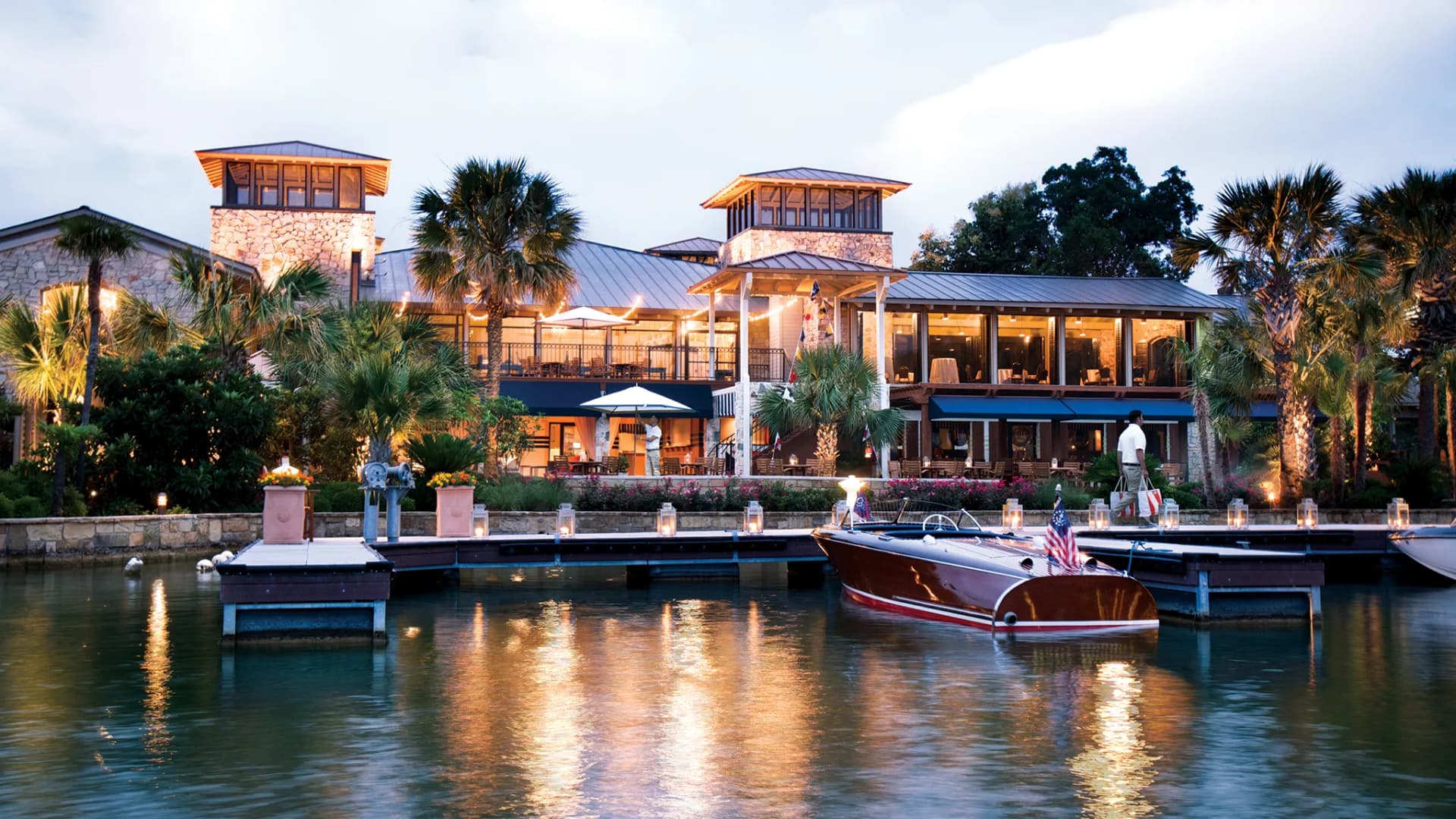 A stunning waterfront view of Horseshoe Bay Resort with boats docked along the serene lake at dusk.