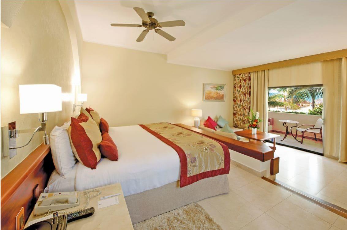 Double bed room with an elevated bed and balcony views of the beach