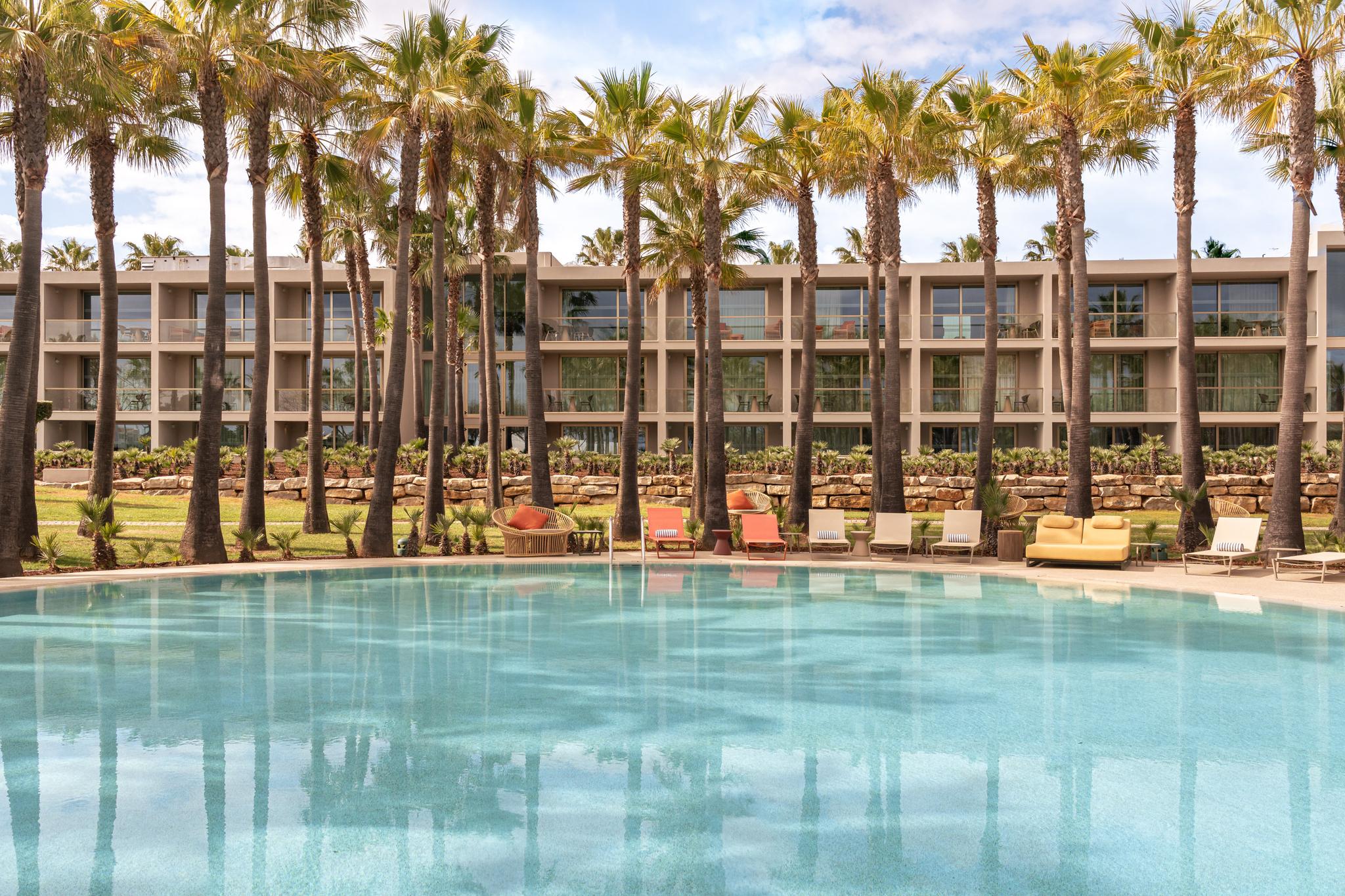 Outdoor swimming pool with palm trees around