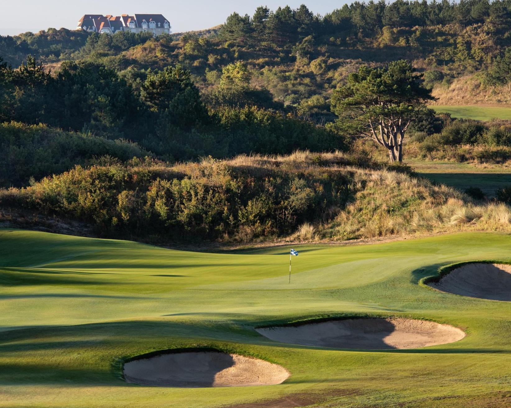 Undulating green with pot bunkers around it