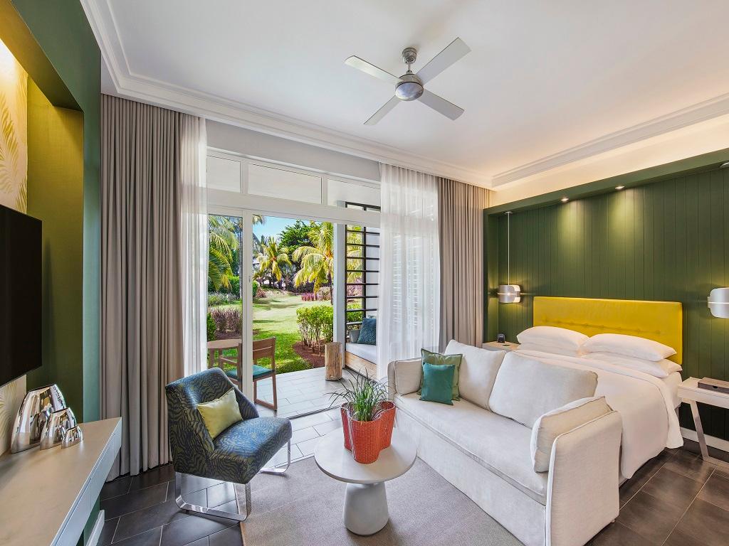 Double bed room at the resort with a patio space that leads to a garden