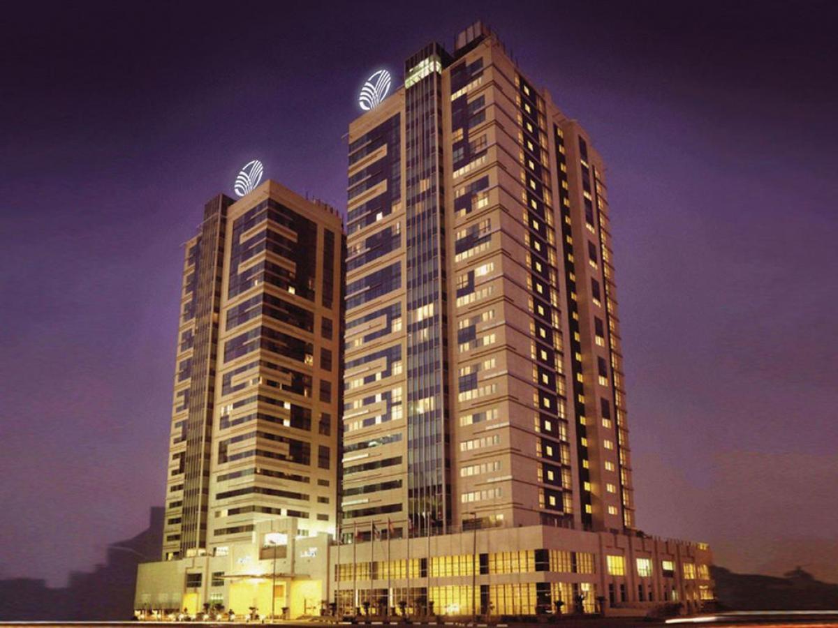 The Media Rotana building towering over with their sign illuminated at the top of the building