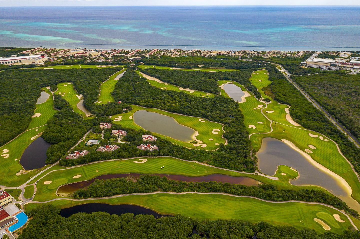 Expansive layout of the golf course with winding fairways and multiple water hazards.