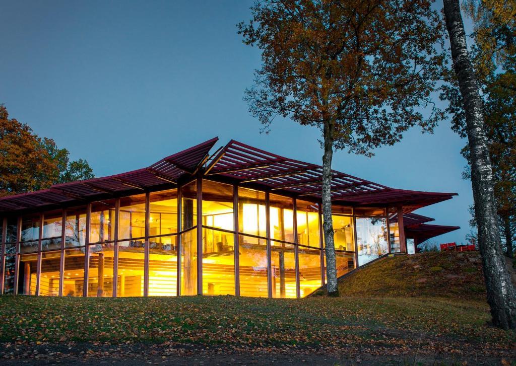 A striking glass-walled building glowing warmly in the evening light.