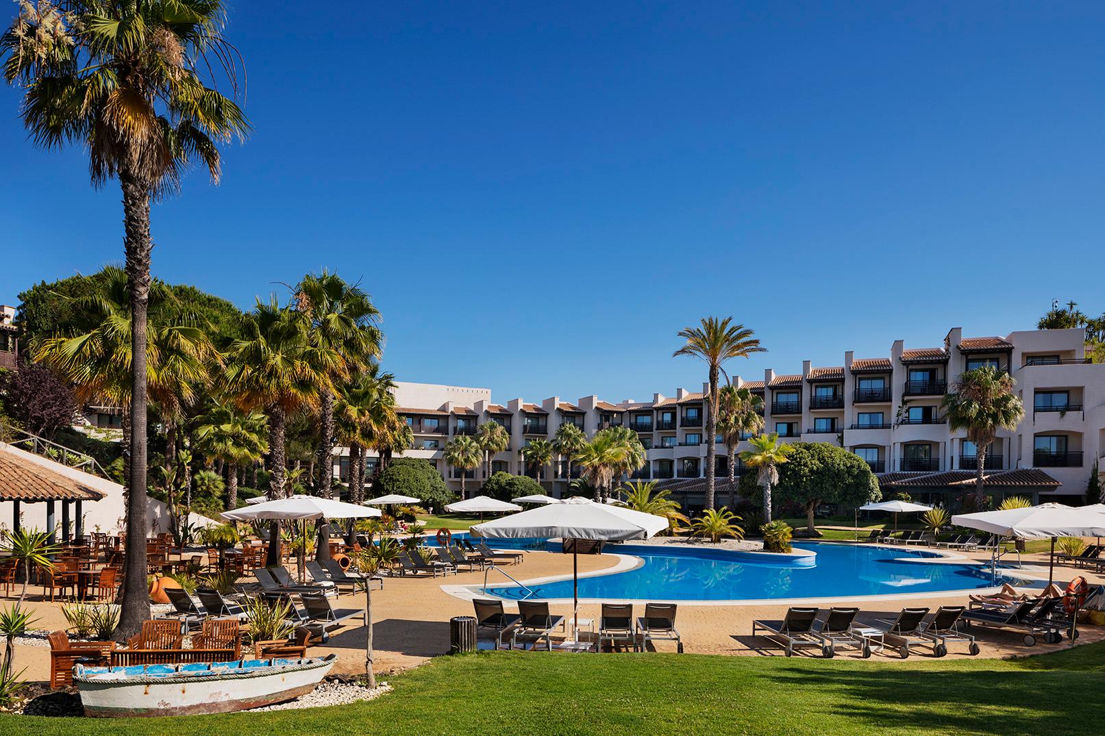 Outdoor swimming pool with hotel rooms behind