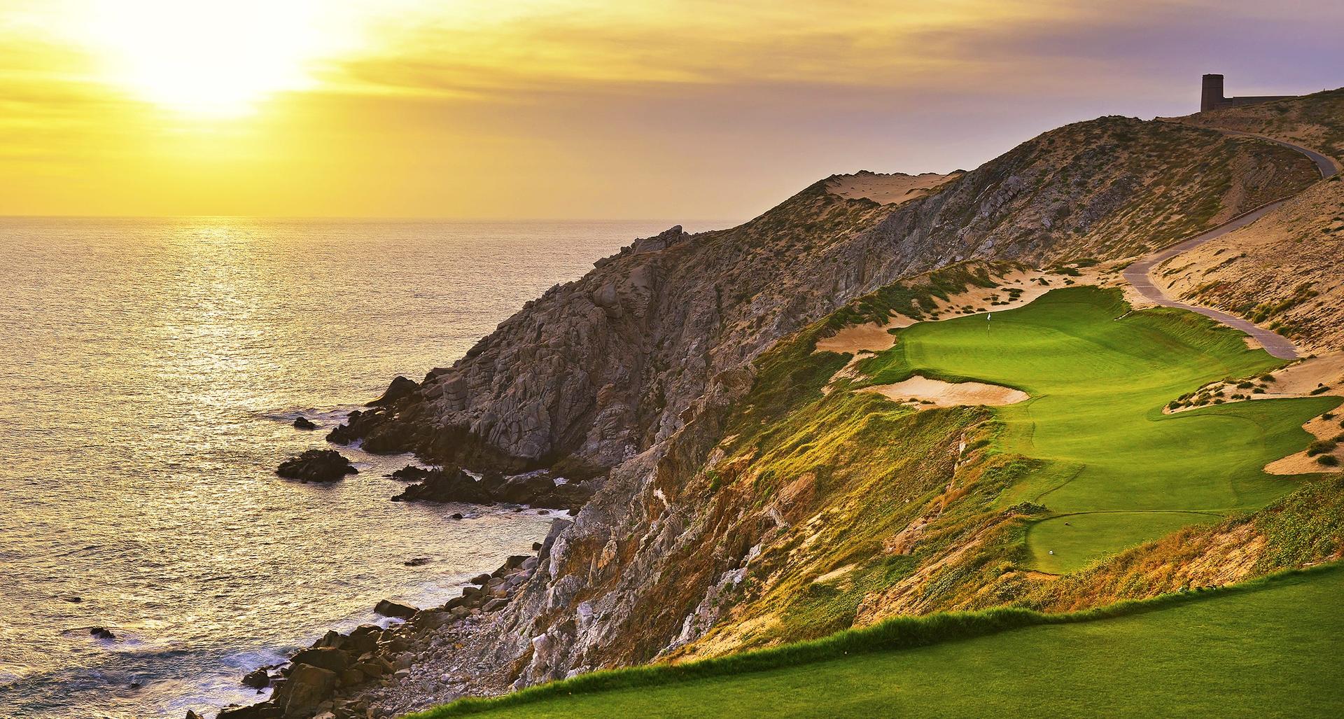 Sun setting over a smooth green placed on the mountain with coastal views