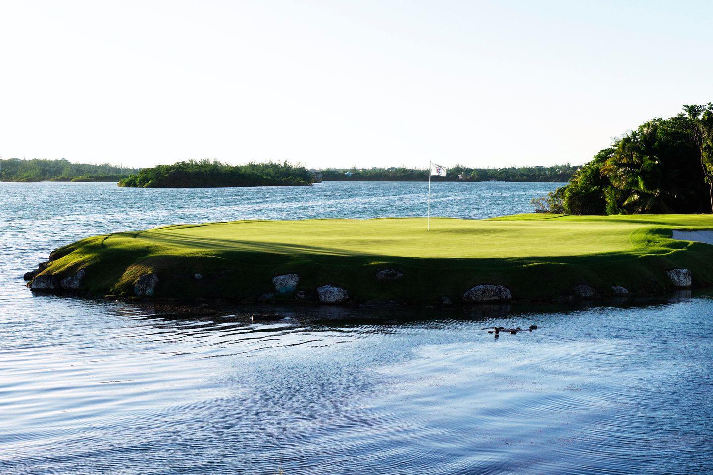 A scenic island green surrounded by calm blue waters.