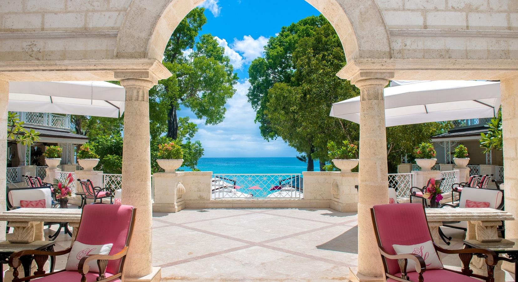 Outdoor seating area with an archway and staircase down to the beach