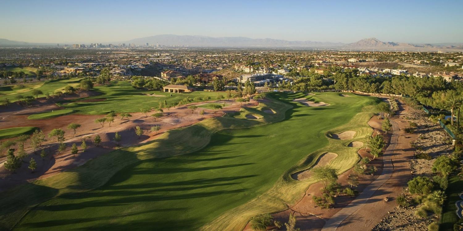 Expansive fairways of Serket Golf Club stretch toward the horizon with the Las Vegas skyline in the distance.